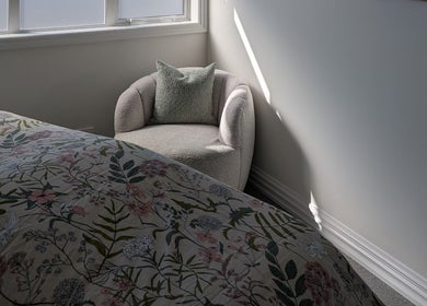 Serene bedroom at My Beauty Treat, Rangiora, Canterbury Region, NZ, featuring a floral bedspread and armchair.