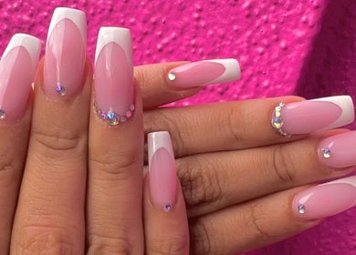 Stunning pink French manicure with gems at Politur Nails Beauty Lounge, Los Angeles, California, US.