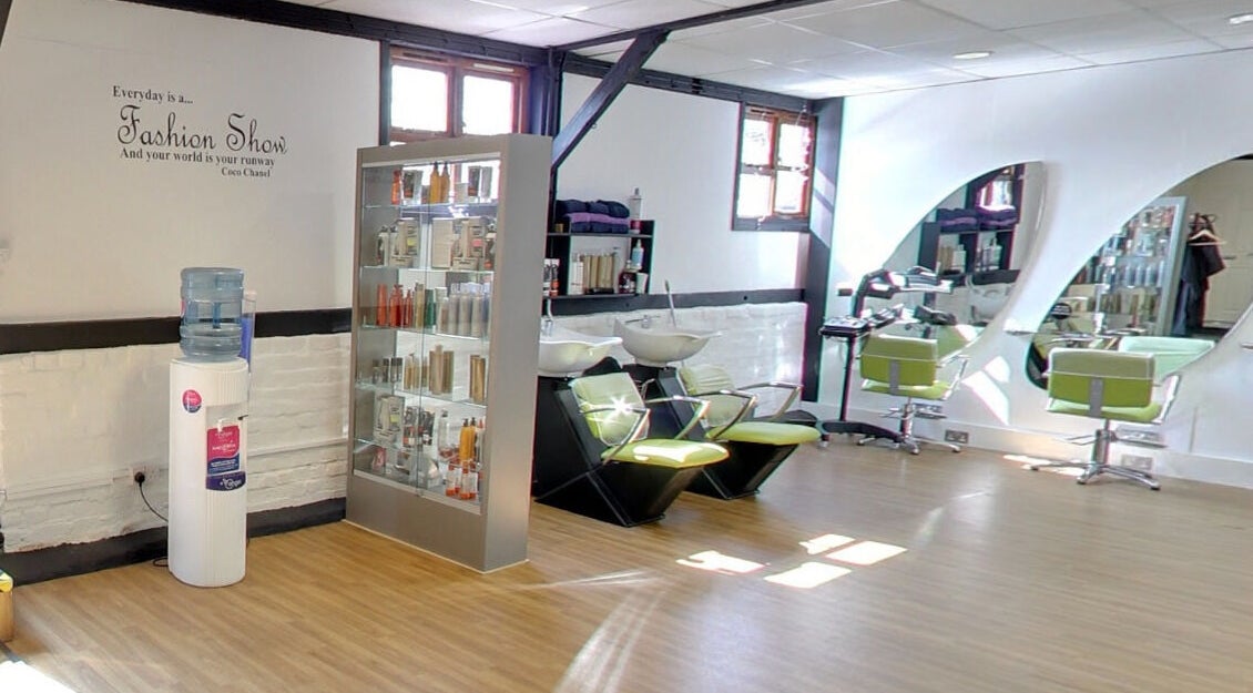 Modern salon interior at The Hair and Beauty Barn, Reading, England, GB, showcasing stylish hair stations and product displays.