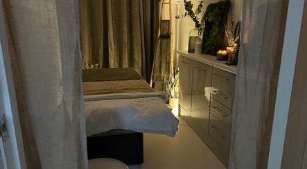 Relaxing treatment room at elixir/ in Royal Leamington Spa, England, GB with candles and soft lighting.