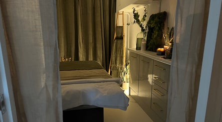 Elegant treatment room at elixir/ Royal Leamington Spa, England, GB, featuring cozy linens and ambient lighting.