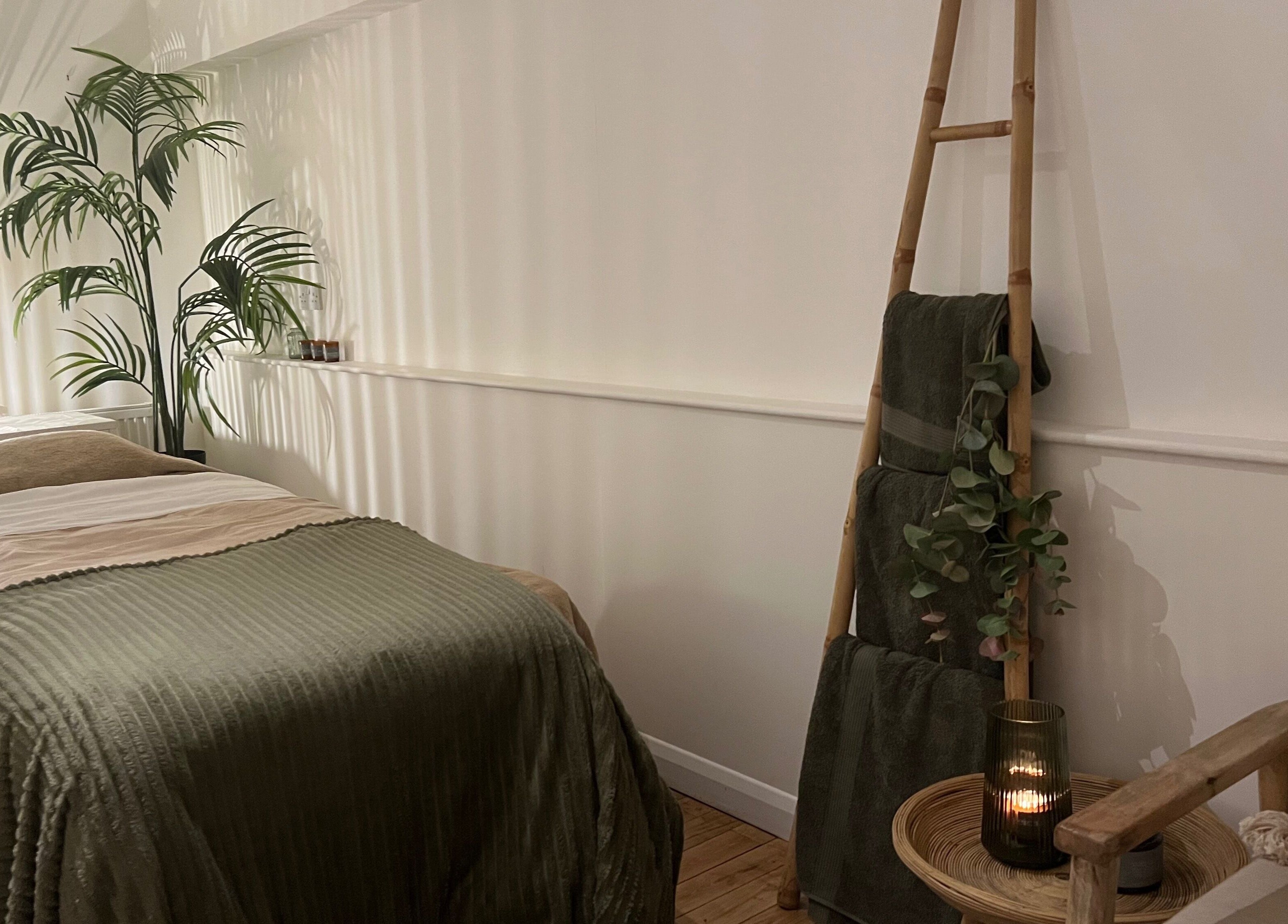 Peaceful treatment room at elixir/ in Royal Leamington Spa, England, with a cozy bed and ambient lighting.