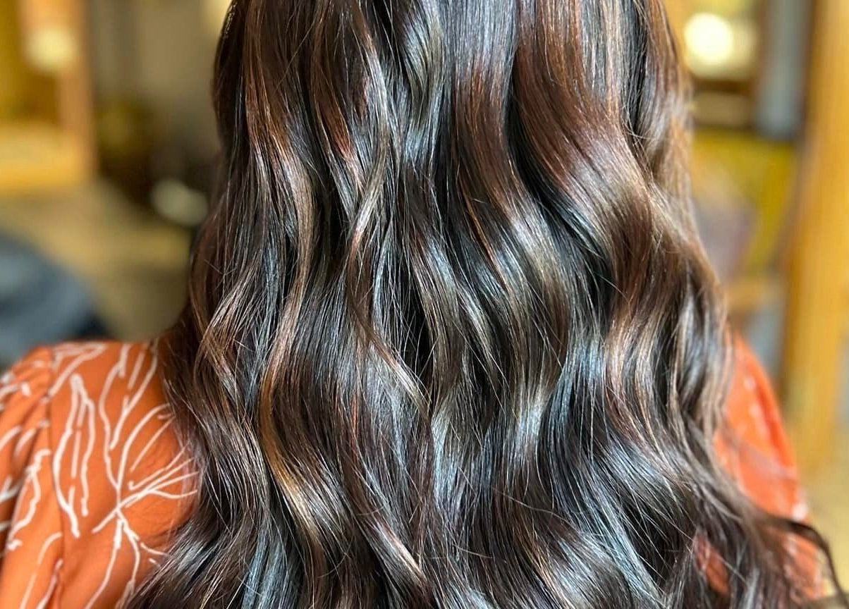 Shiny, wavy brunette hair styled at Lucy at C Reflections Salon & Day Spa, Morrill, Nebraska, US.