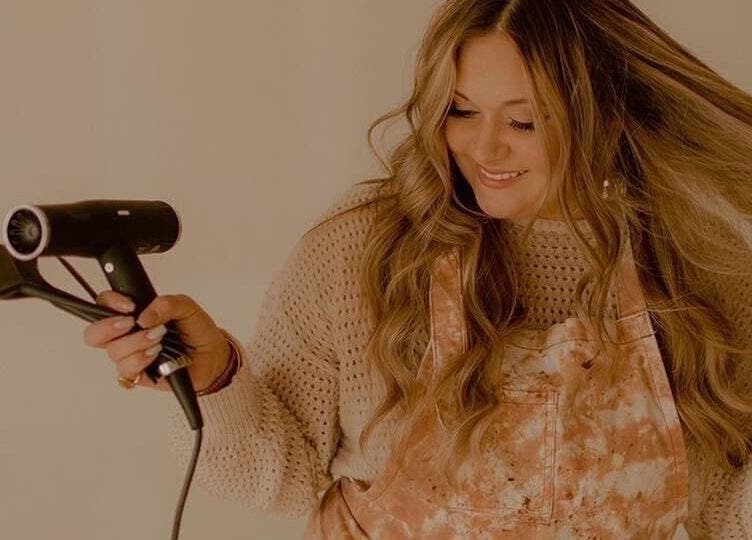 Stylist smiling while blow-drying hair at Lucy at C Reflections Salon & Day Spa, Morrill, Nebraska, US.
