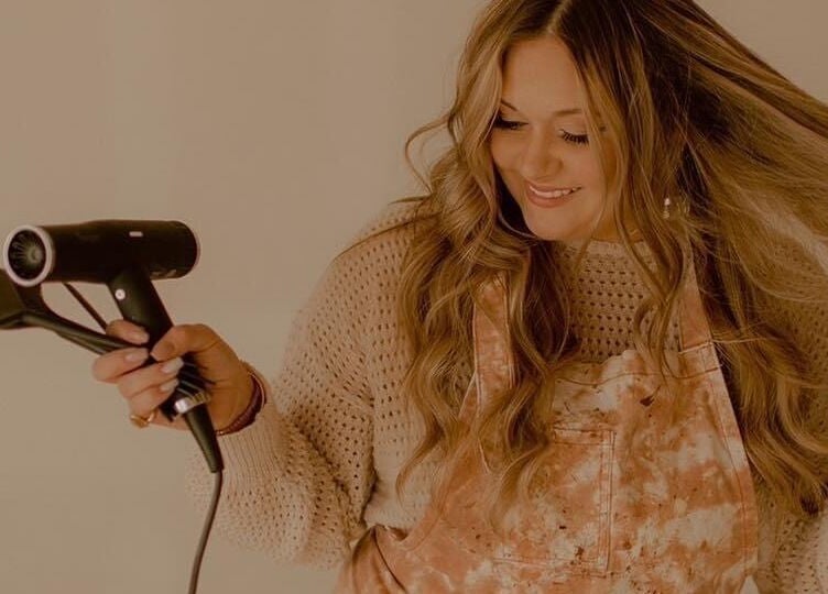 Stylist smiling while blow-drying hair at Lucy at C Reflections Salon & Day Spa, Morrill, Nebraska, US.