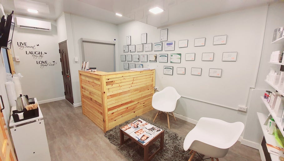 Reception area at The DermLab Freeport TT with cozy seating and certificate display.