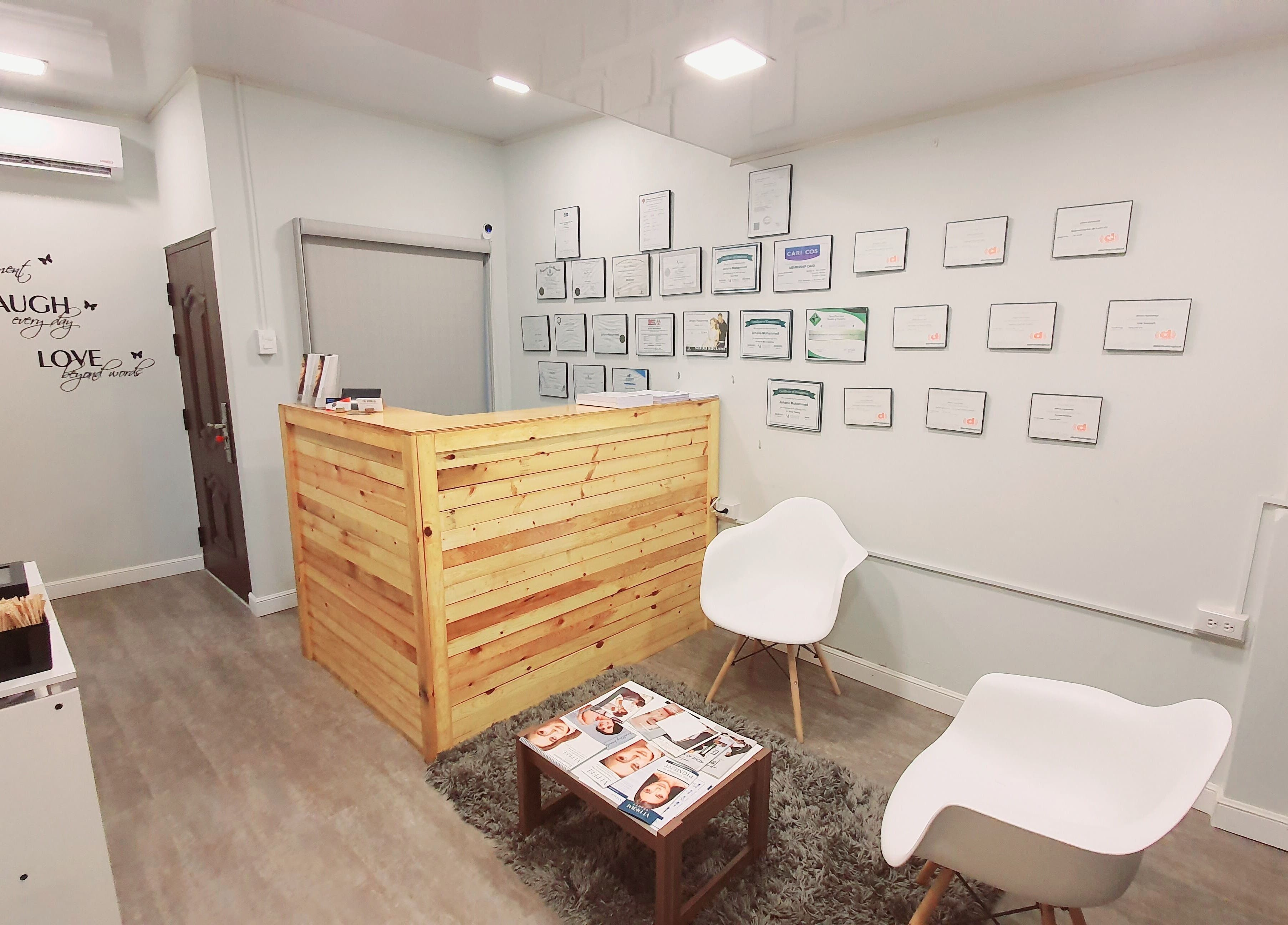 Reception area at The DermLab Freeport TT with cozy seating and certificate display.