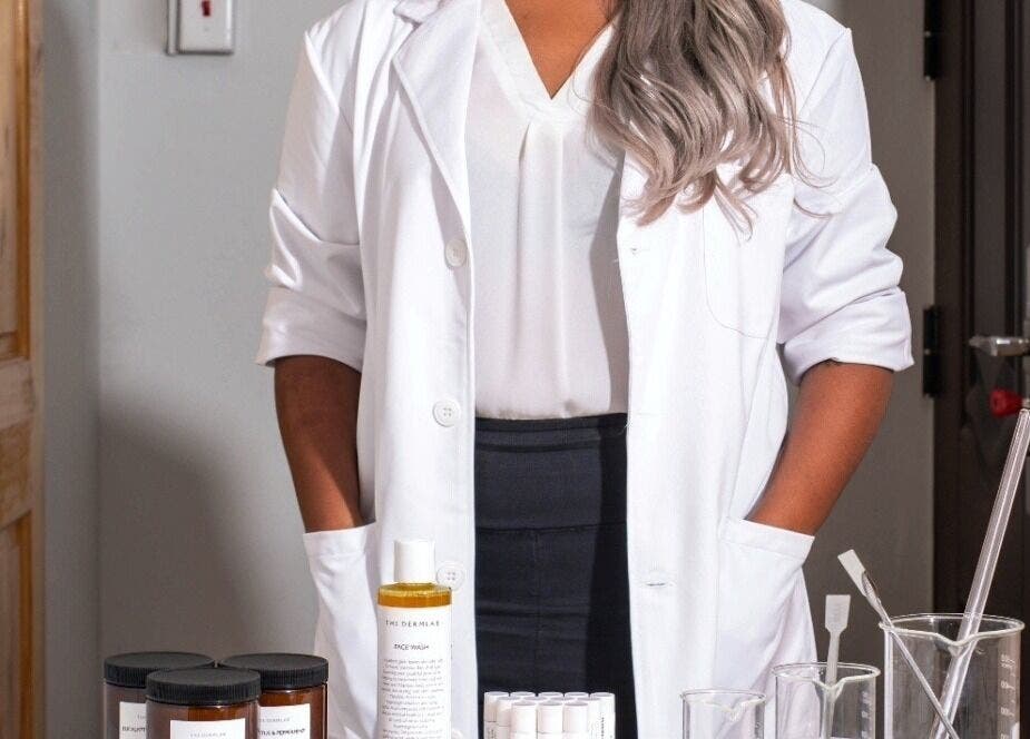 A professional at The DermLab in Freeport, TT with skincare products and lab tools.