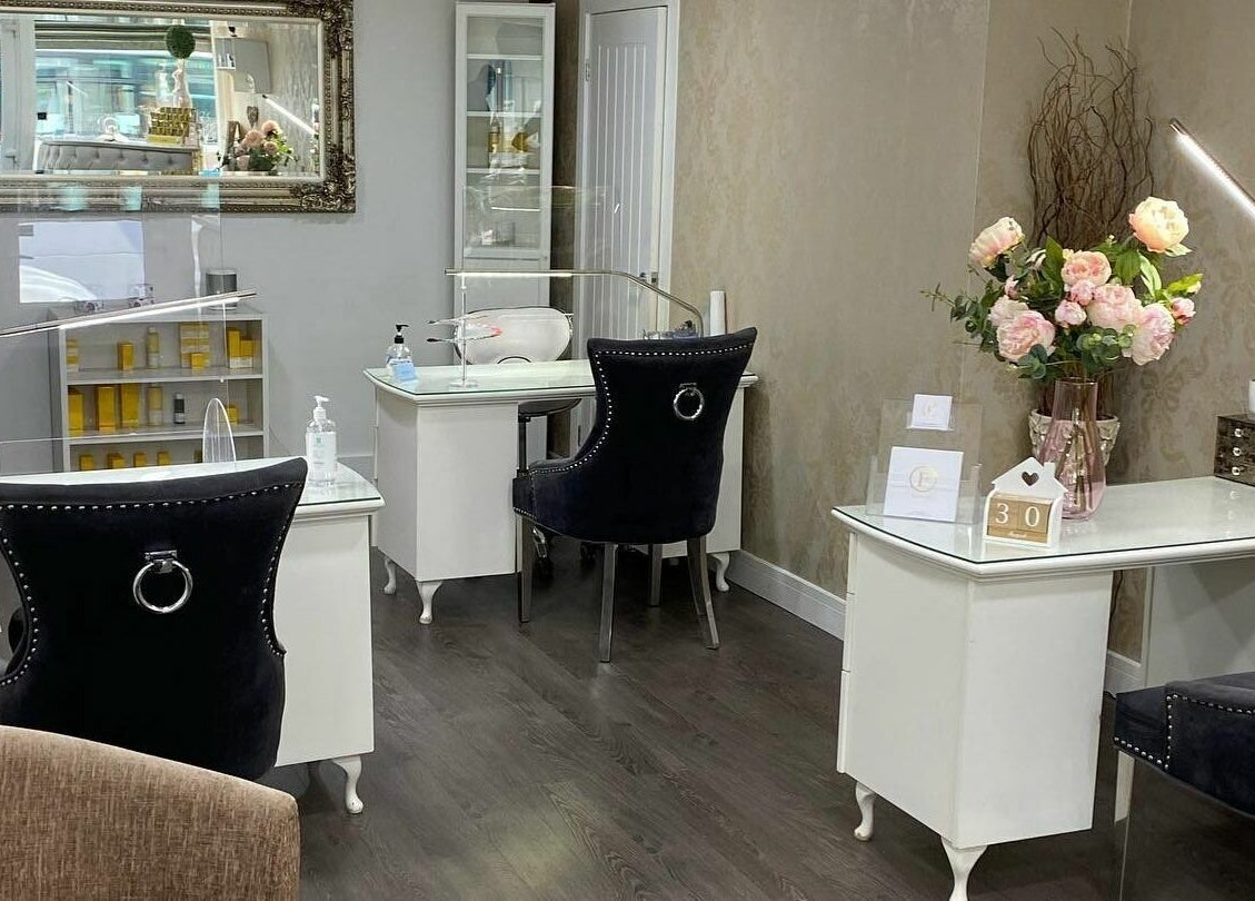 Interior of Flawless in Shaw, England, GB featuring nail stations and floral decor.