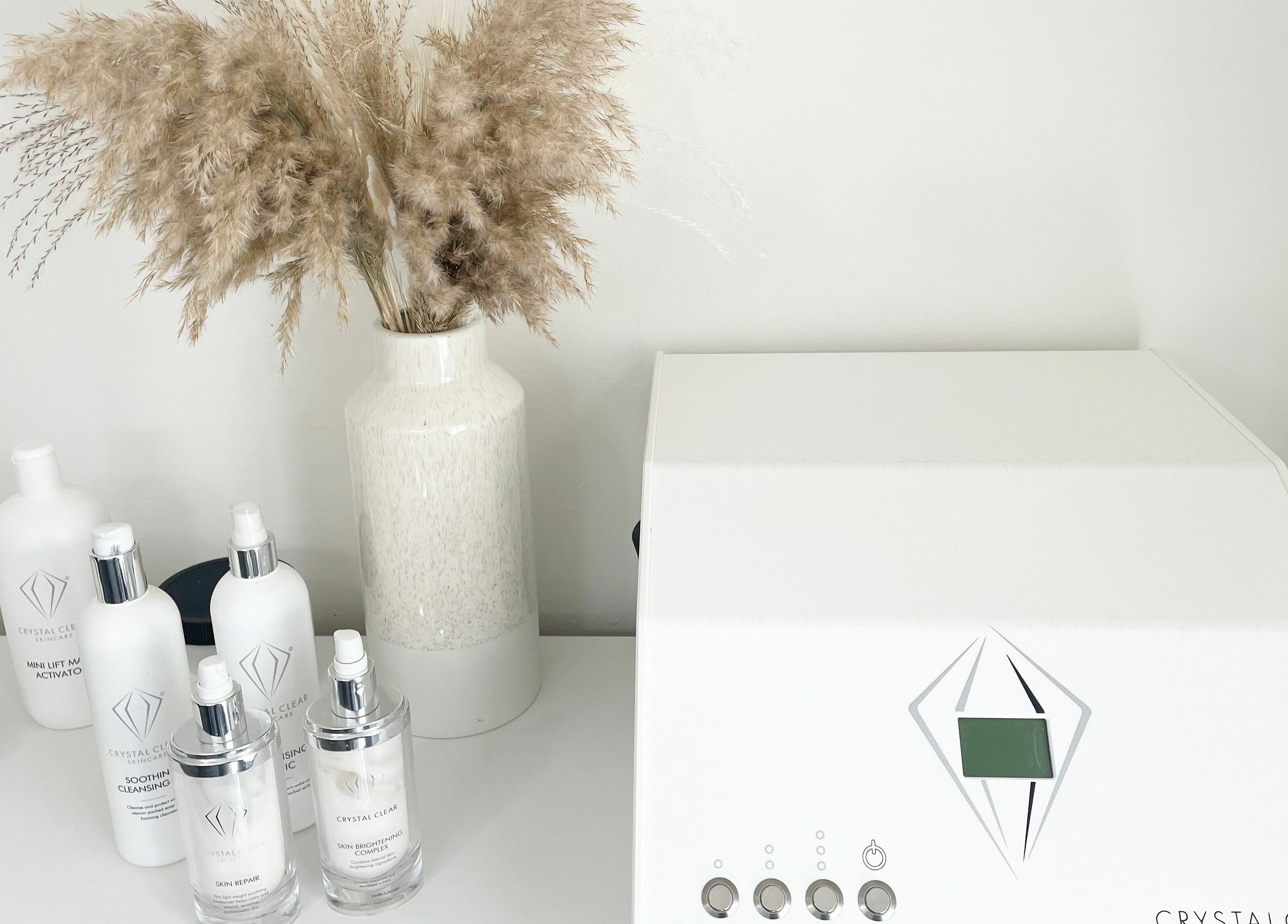 Aesthetic skincare setup at Flawless, Shaw, England, GB featuring crystal clear bottles and spa equipment.