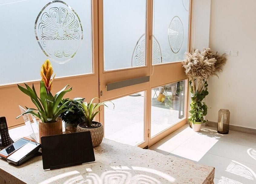 Calamantina's bright, welcoming reception in Aqaba, Aqaba Governorate, JO, featuring plants and natural lighting.