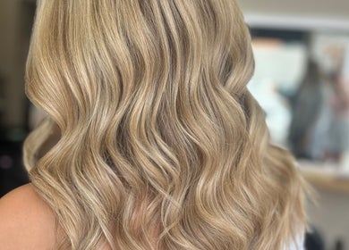Blonde wavy hair styled at Hairology Rushden, Rushden, England, GB showcasing vibrant and elegant curls.