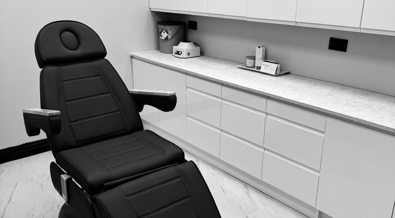 Modern treatment room at The Dermagen Clinic Glasgow, featuring a sleek chair and cabinets. Located in Glasgow, Scotland, GB.