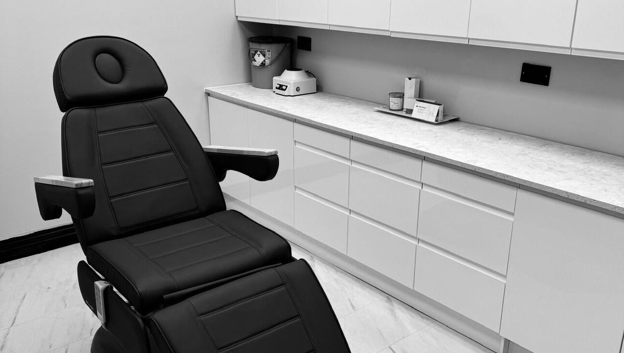 Relaxing treatment room at The Dermagen Clinic Weybridge, Weybridge, England, GB with a sleek black chair.