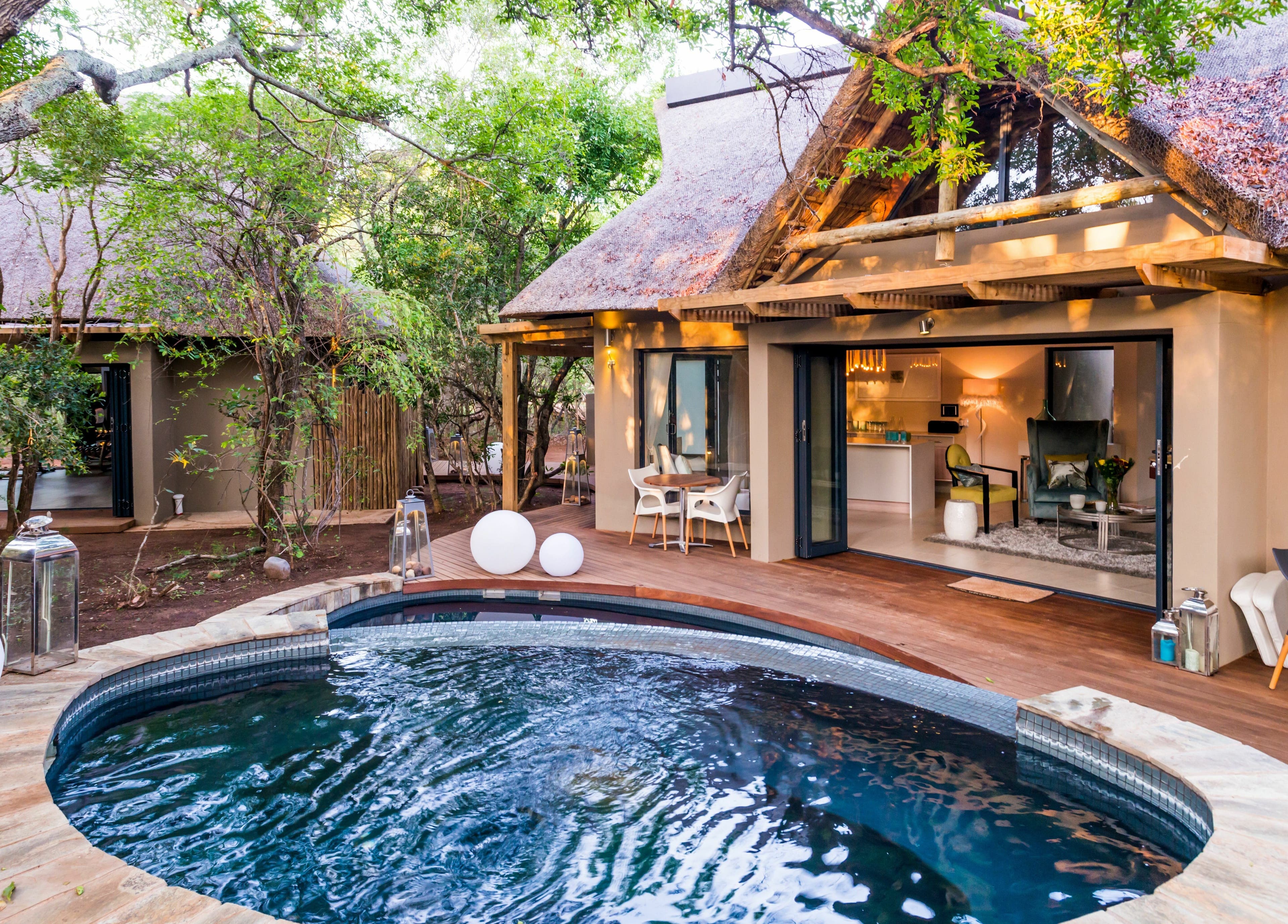 Relaxing outdoor pool area at AM Spa Hoedspruit in Hoedspruit, Limpopo, ZA surrounded by lush greenery.