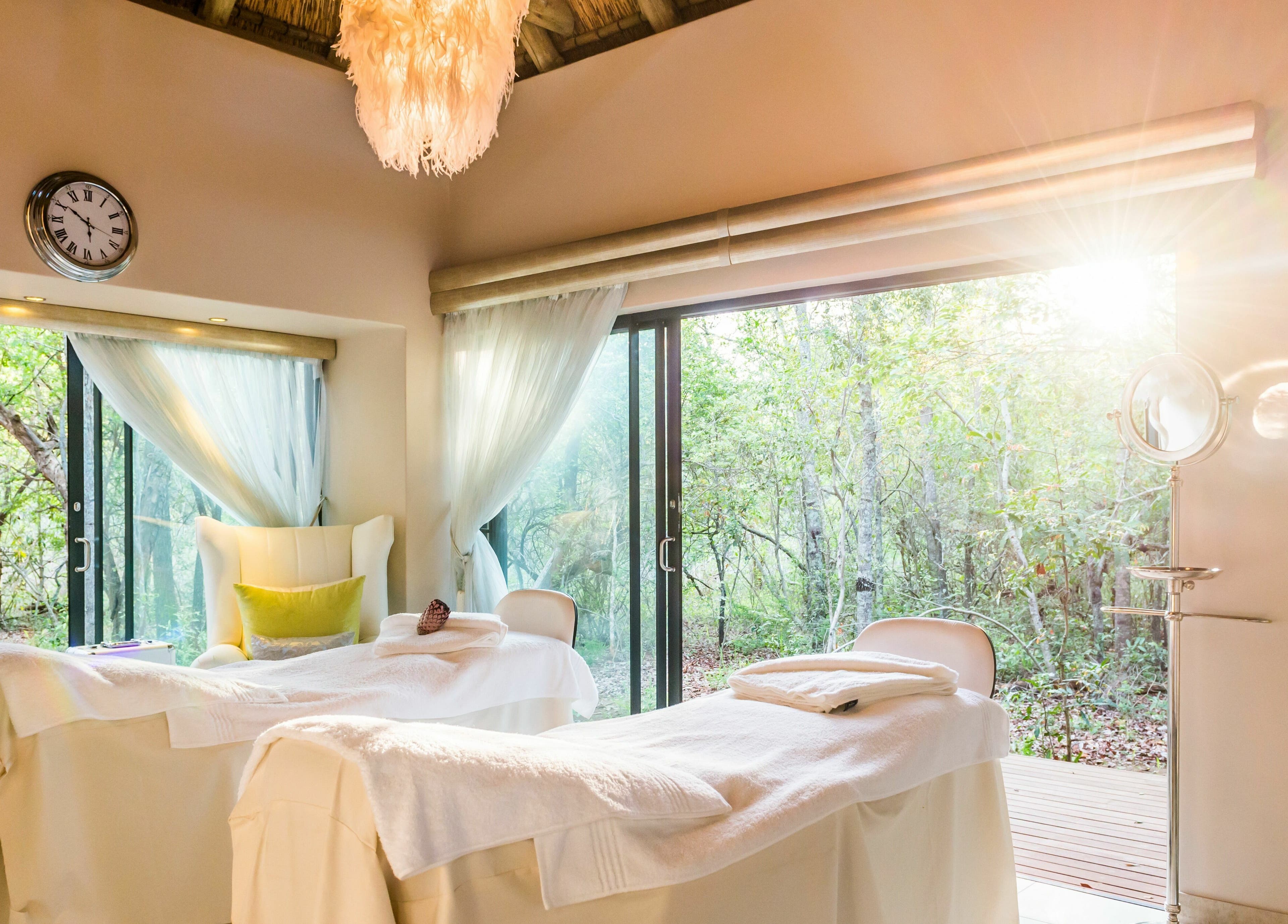Relaxing spa treatment room at AM Spa Hoedspruit, Hoedspruit, Limpopo, ZA, with serene forest views.
