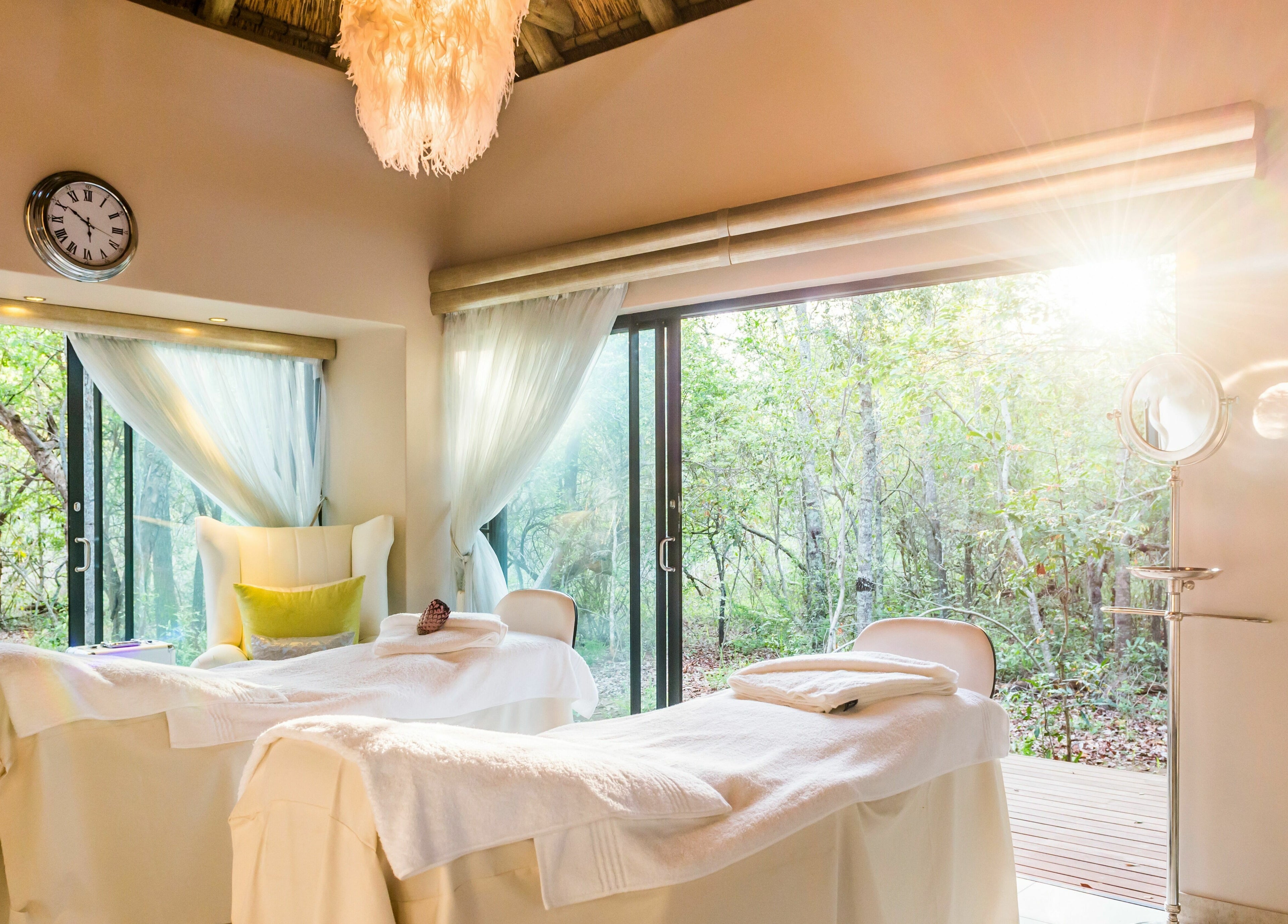 Relaxing spa treatment room at AM Spa Hoedspruit, Hoedspruit, Limpopo, ZA, with serene forest views.