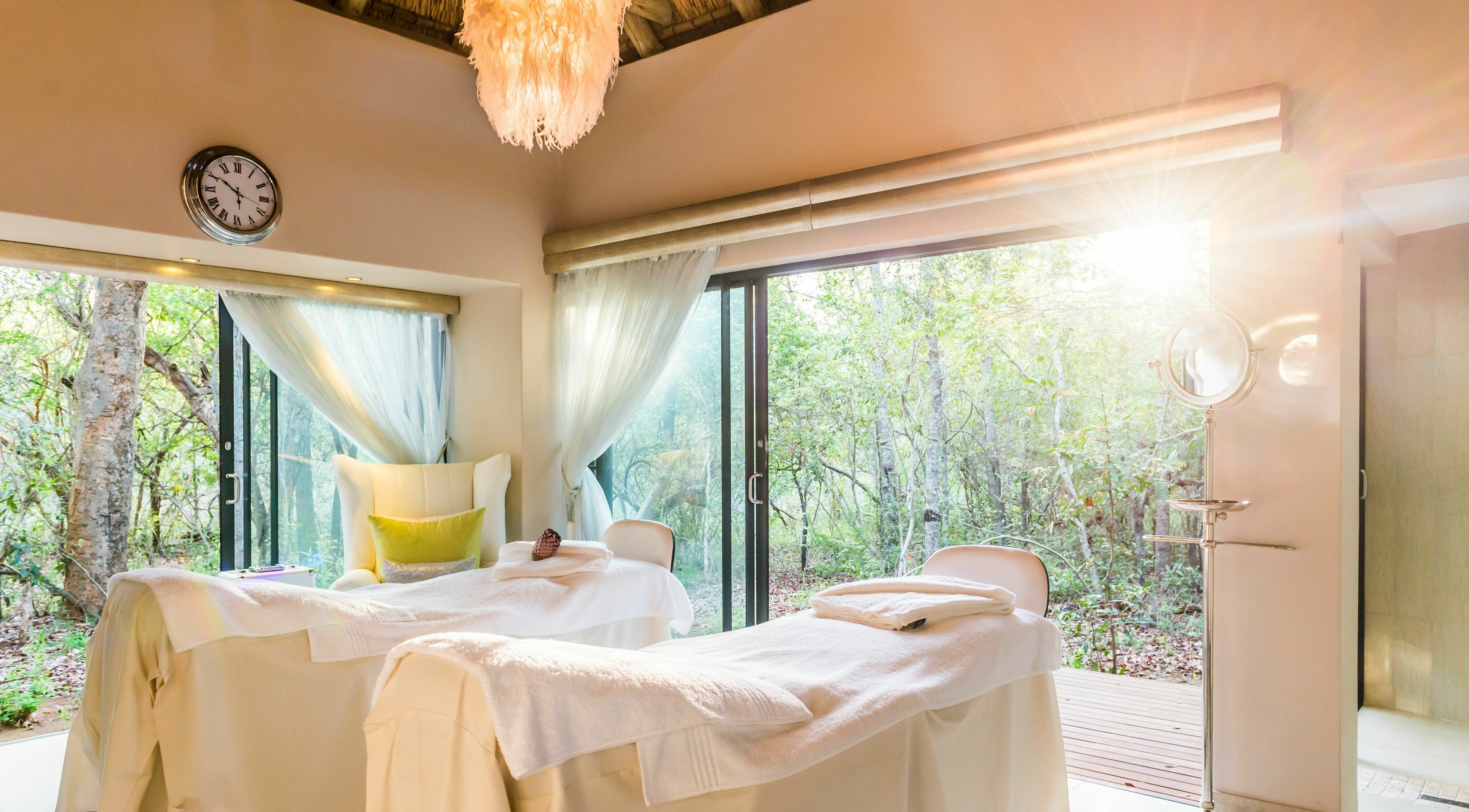 Relaxing spa treatment room at AM Spa Hoedspruit, Hoedspruit, Limpopo, ZA, with serene forest views.
