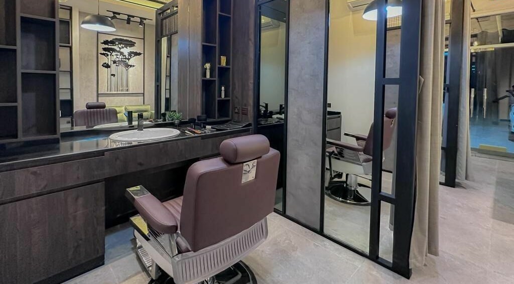 Interior of AK Barbershop (Al Dhait) in Ras Al-khaimah, Ras Al Khaimah, AE showcasing a plush barber chair and chic decor.