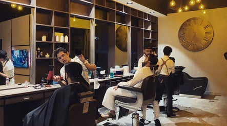 Stylish interior of Ak Barbershop (Mina Alarab), Al Jazirah Al Hamra, Ras al Khaimah, AE with barbers at work.