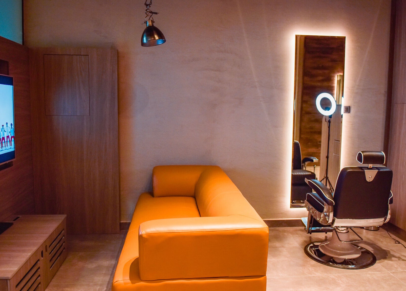 Sophisticated interior of Fade in Muscat, Bosher, OM with a modern sofa, TV, and styling chair.