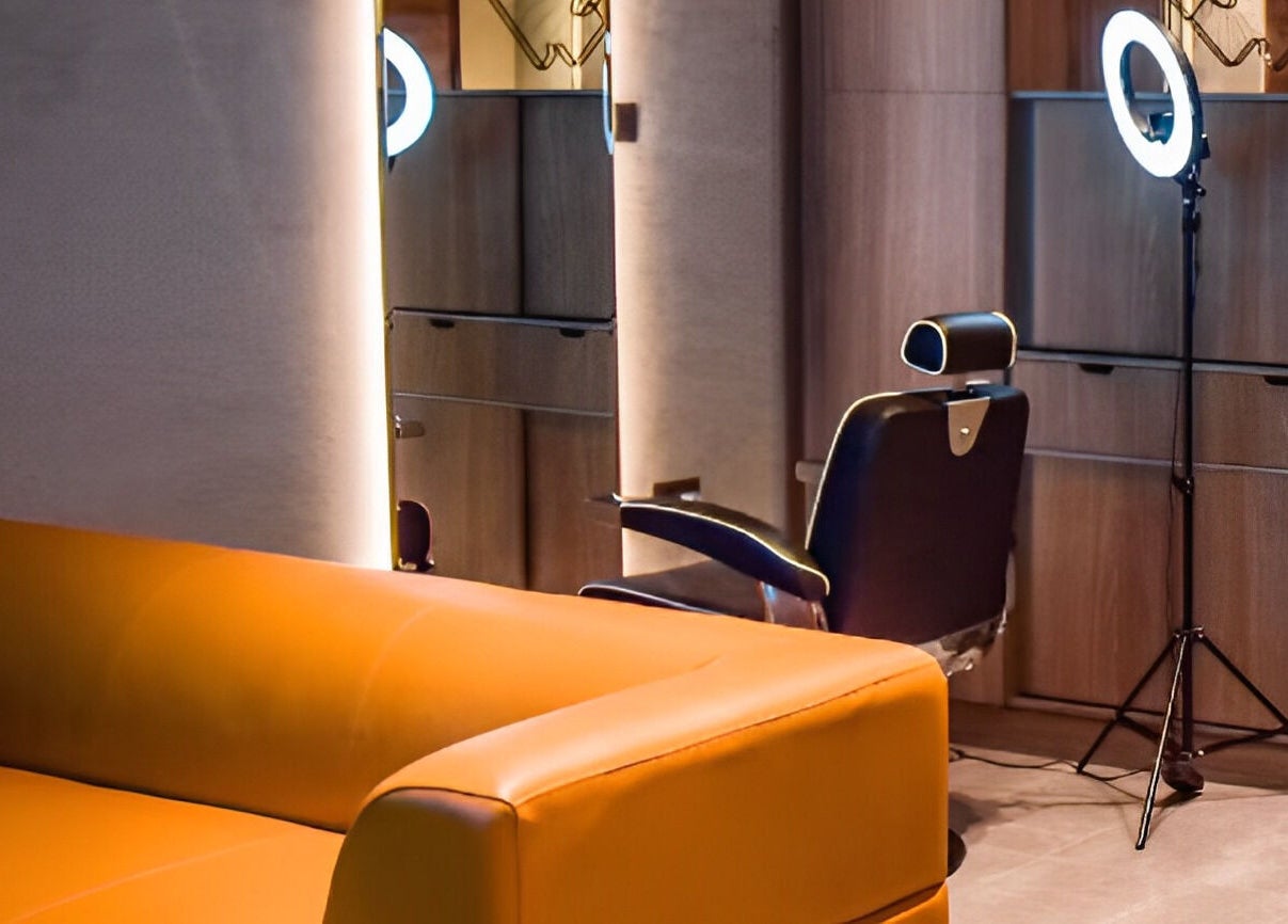 Stylish lounge area at Fade, Muscat, Bosher, OM, featuring a comfortable orange sofa and modern decor.