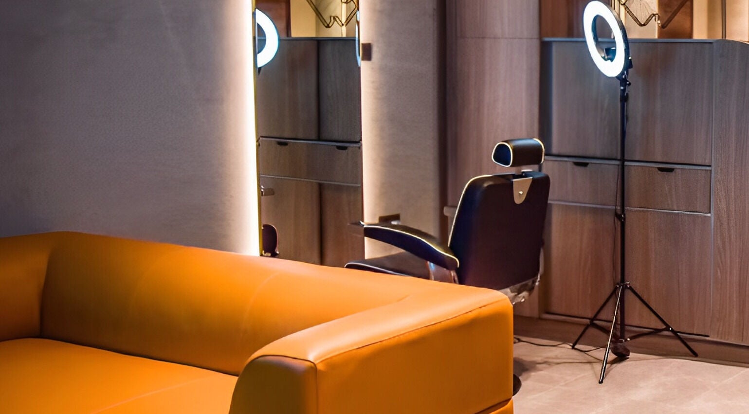 Stylish lounge area at Fade, Muscat, Bosher, OM, featuring a comfortable orange sofa and modern decor.