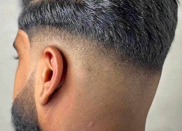 Close-up of a sharp fade haircut at Fade, Muscat, bosher, OM.