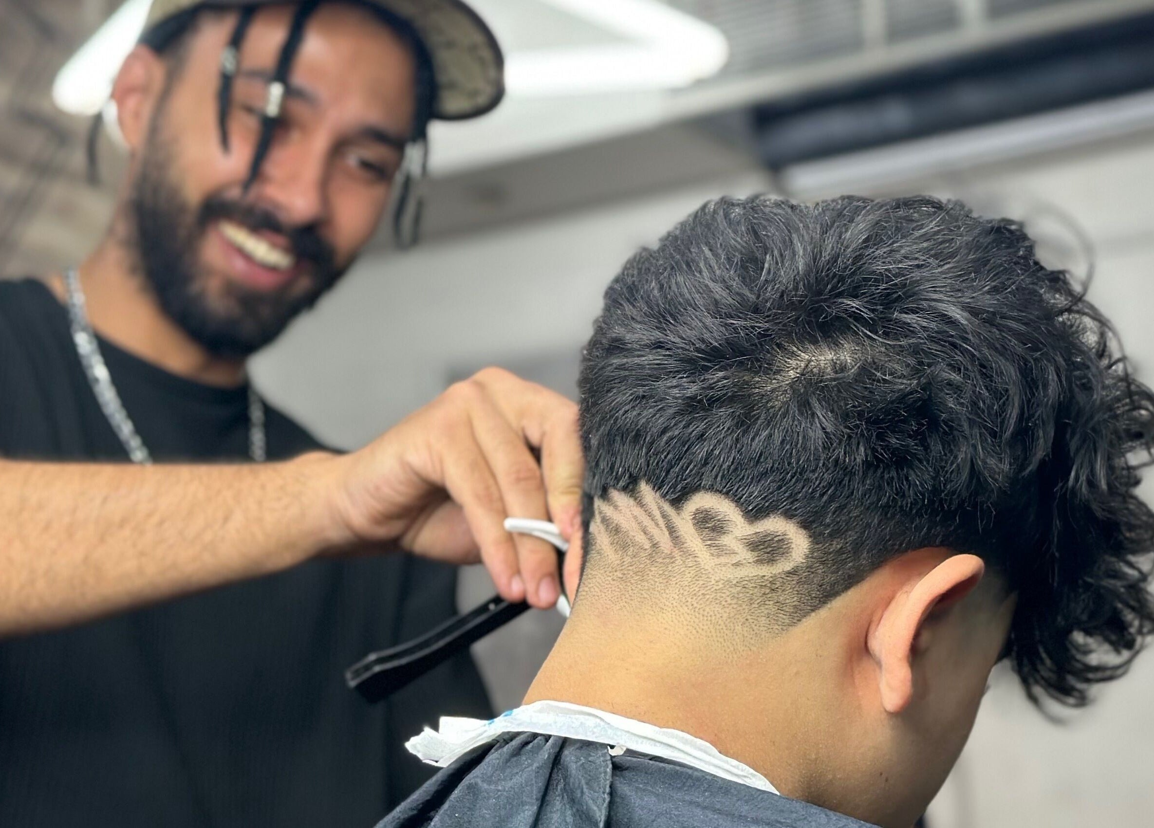 Barber at Fade crafting a stylish hair design in Muscat, bosher, OM.