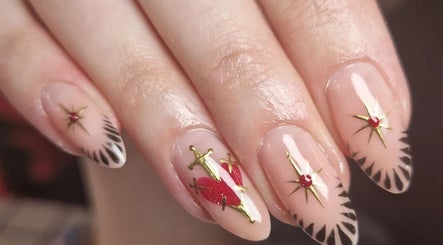 Intricate nail art at The Painted Parlour, Holmfirth, England, GB with red accents and gold details.