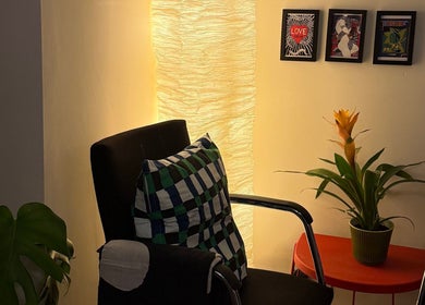 Relaxing chair, vibrant plant, and framed art at The Painted Parlour, Holmfirth, England, GB.