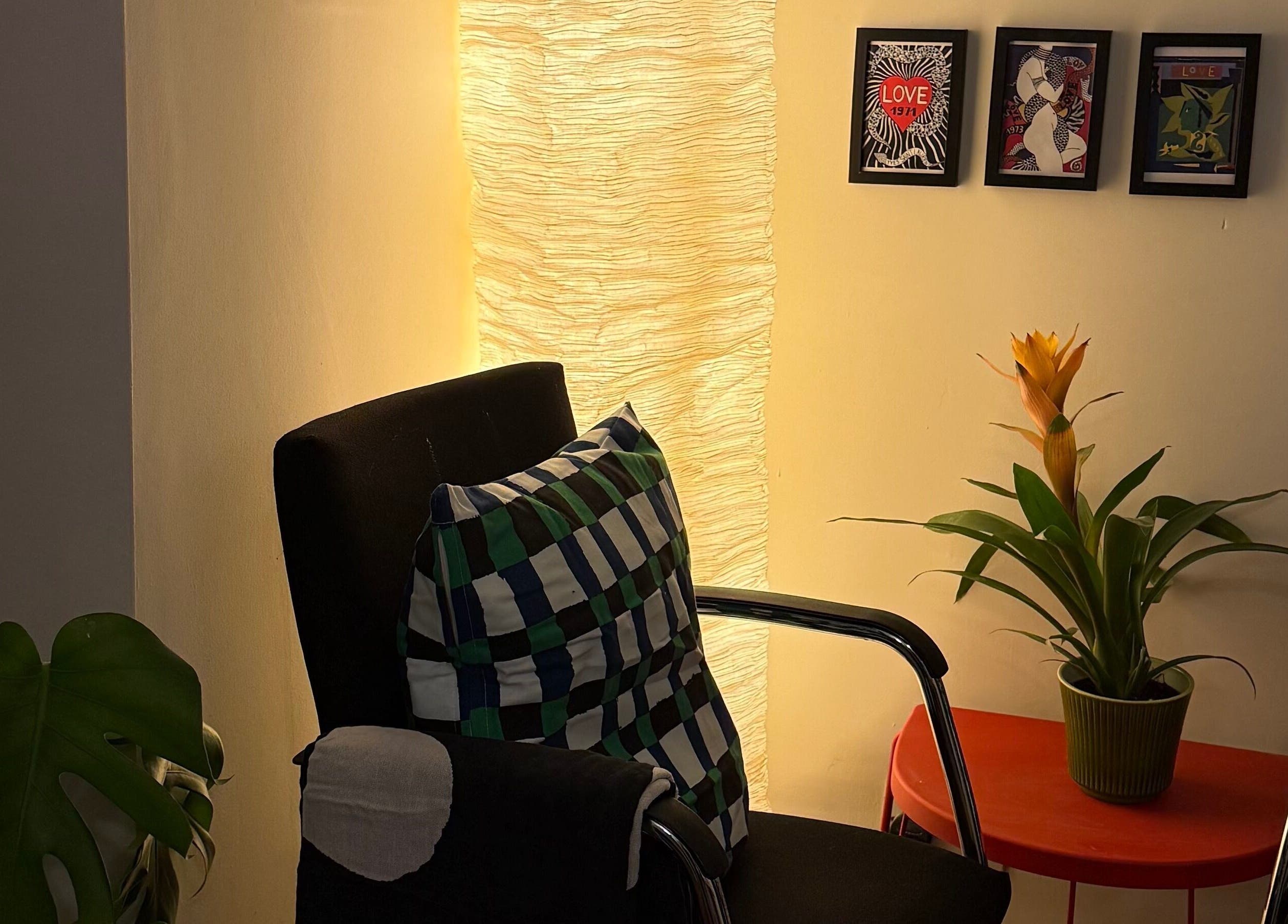 Relaxing chair, vibrant plant, and framed art at The Painted Parlour, Holmfirth, England, GB.