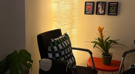 Relaxing chair, vibrant plant, and framed art at The Painted Parlour, Holmfirth, England, GB.