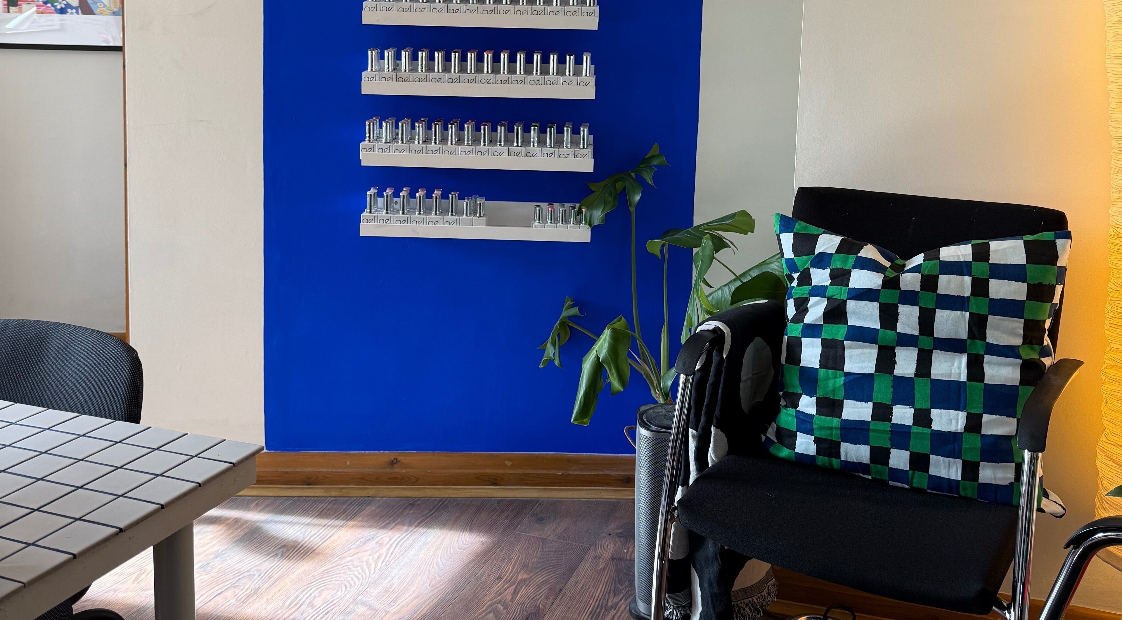 Elegant waiting area in The Painted Parlour, Holmfirth, England, GB with colorful decor and lush plant.