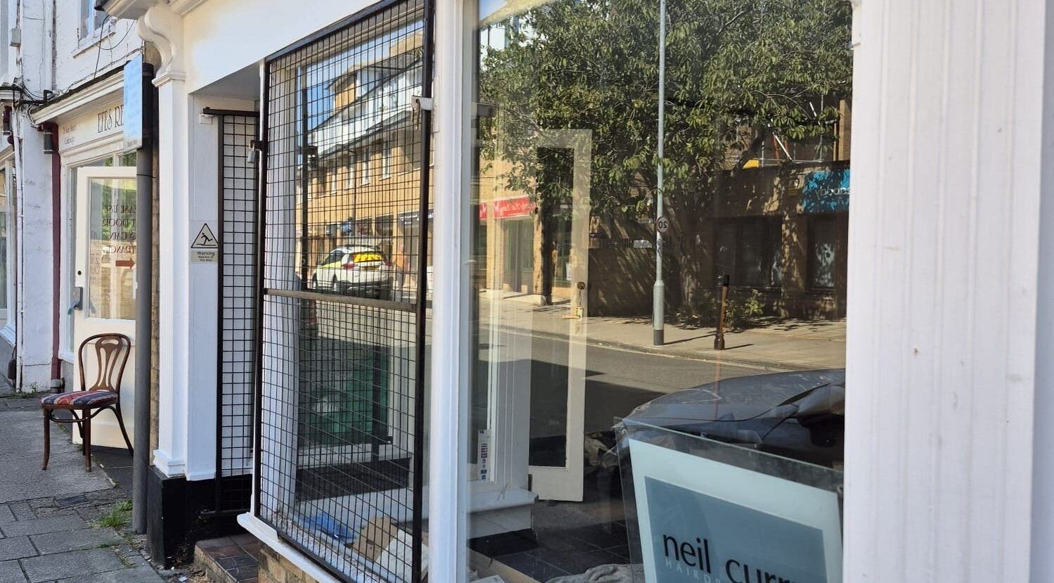 Front view of Neil Curry Hairdressing Ltd in Cambridge, England, GB featuring street reflection.