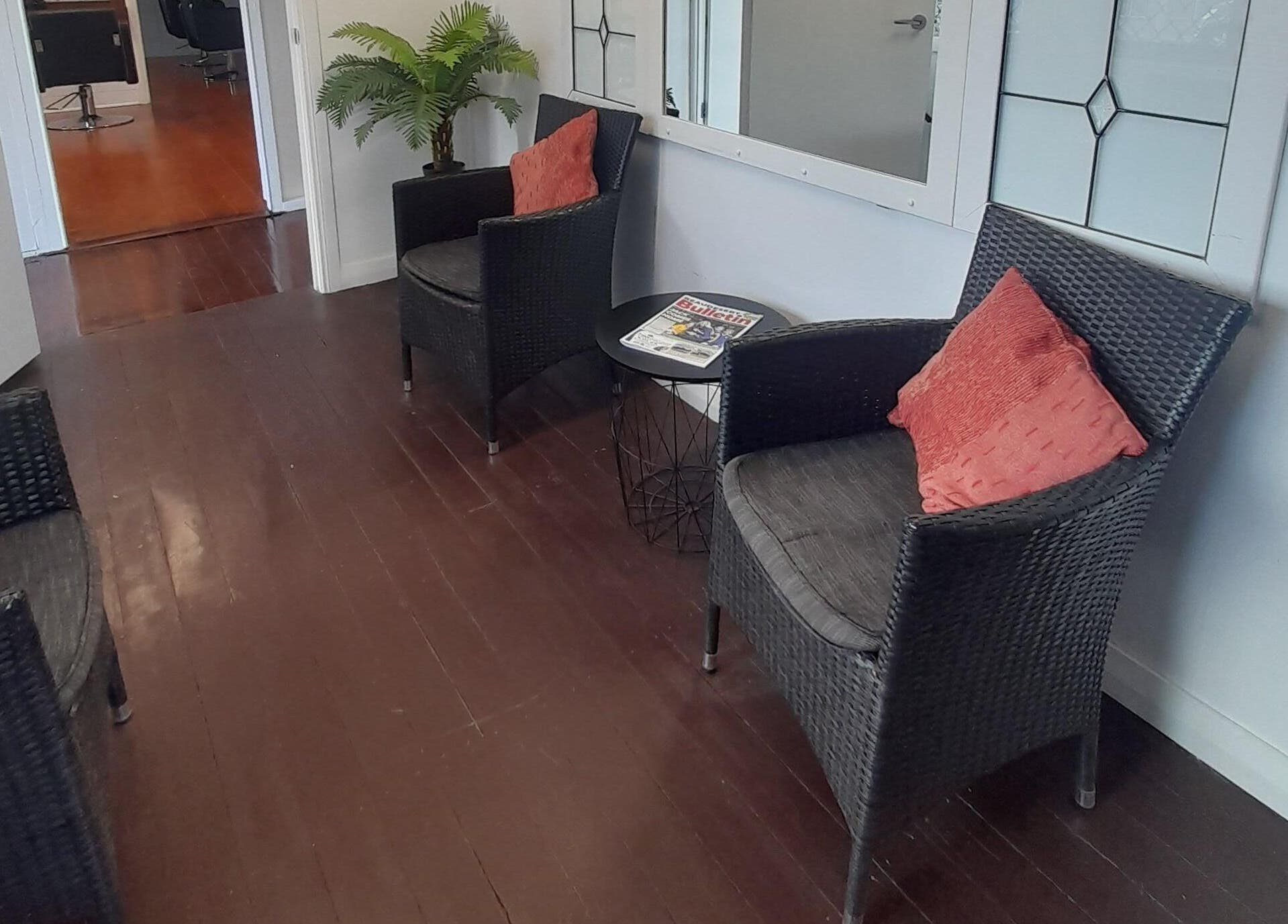 Inviting seating area at Sadie's Hair Shed in Beaudesert, Queensland, AU with rattan chairs and cushions.