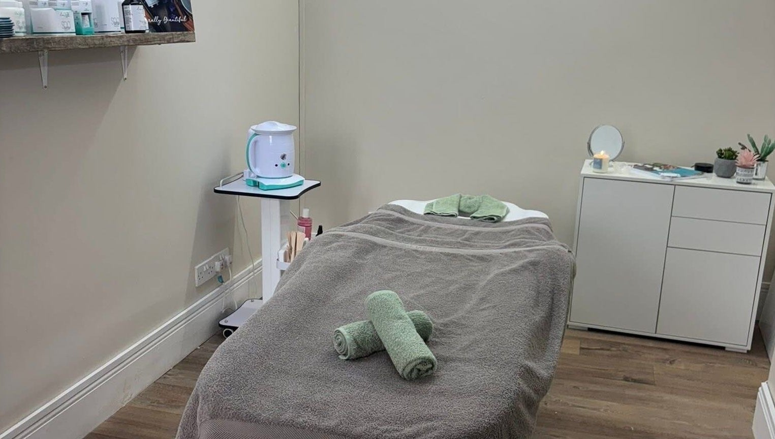 Relaxing treatment room at The Hive Beauty, Holistics & Hair in Cullompton, England, GB, with cozy massage bed.