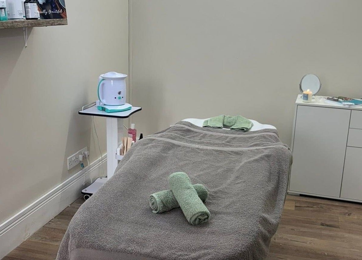 Relaxing treatment room at The Hive Beauty, Holistics & Hair in Cullompton, England, GB, with cozy massage bed.