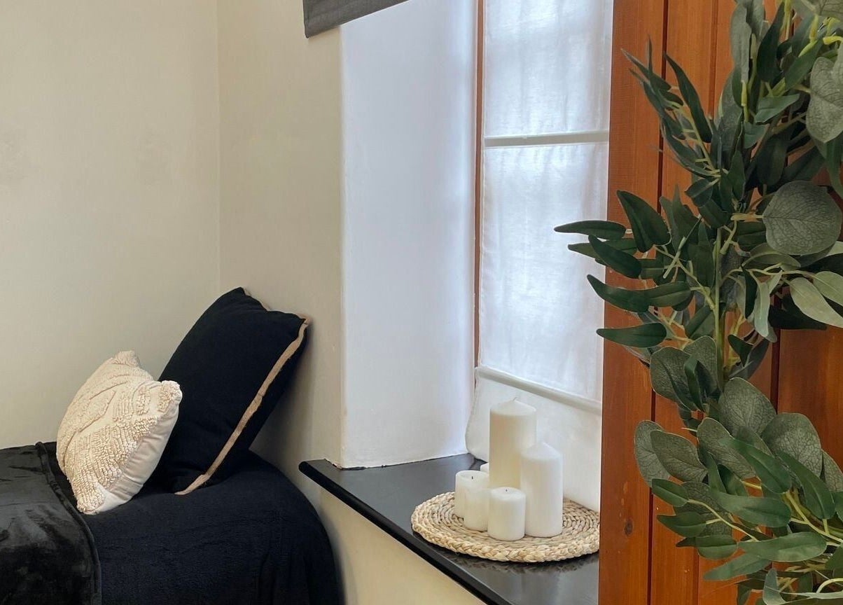 Cozy treatment room at Bavaro’s Hair Design Ltd, Aldwincle, England, GB with candles and greenery.