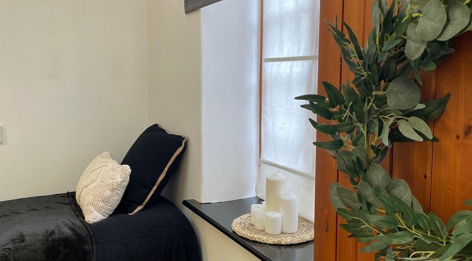 Cozy treatment room at Bavaro’s Hair Design Ltd, Aldwincle, England, GB with candles and greenery.