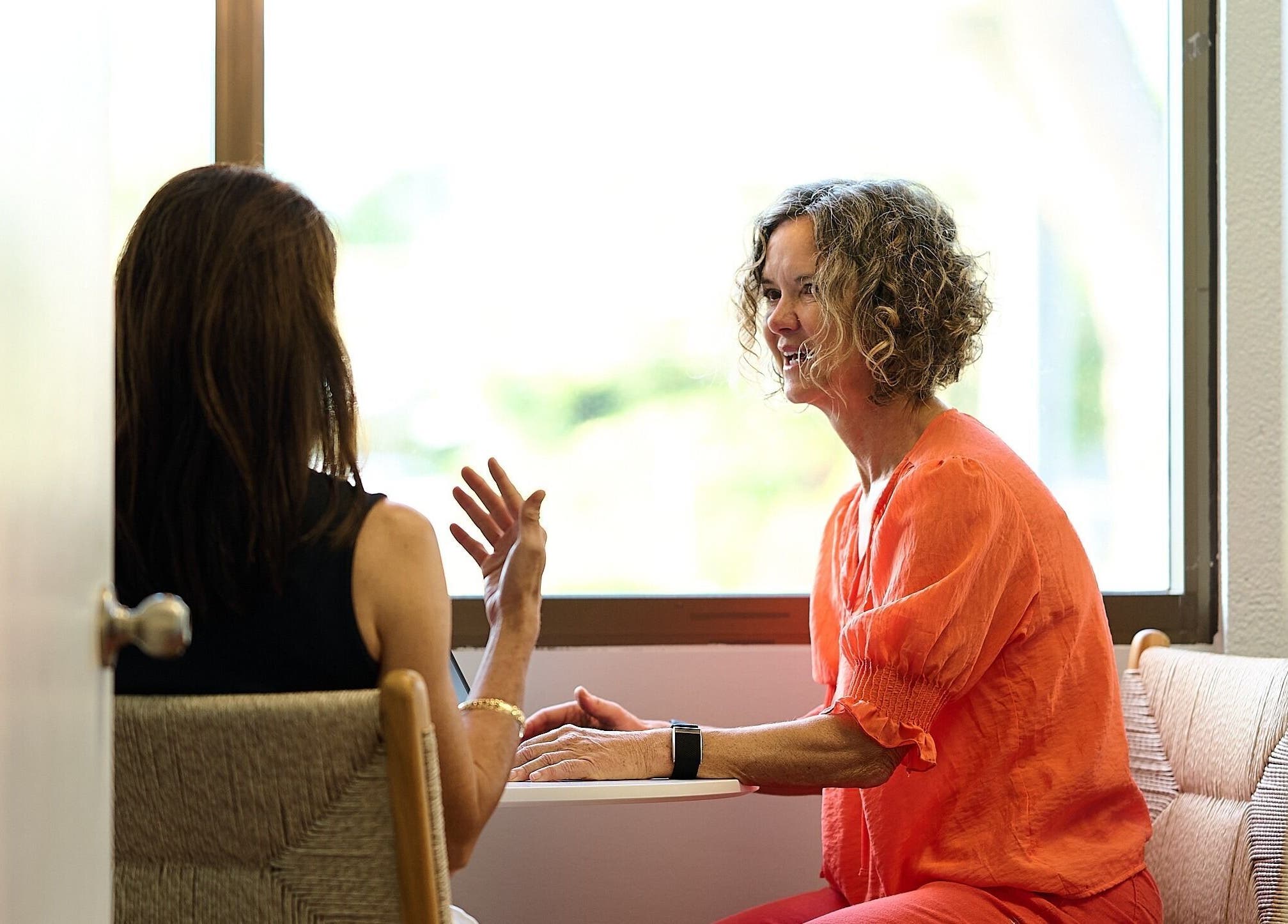 Two women talking at Enhance Hawaiʻi in Kailua, Hawaii, US, in a tranquil room.