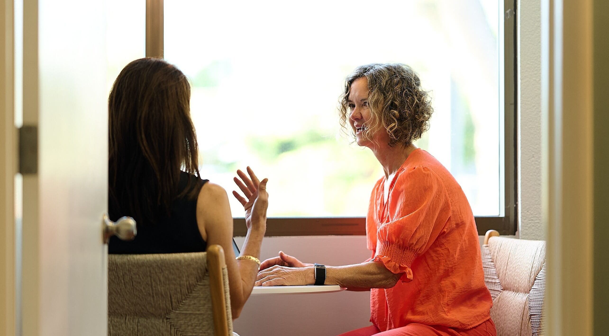 Two women talking at Enhance Hawaiʻi in Kailua, Hawaii, US, in a tranquil room.