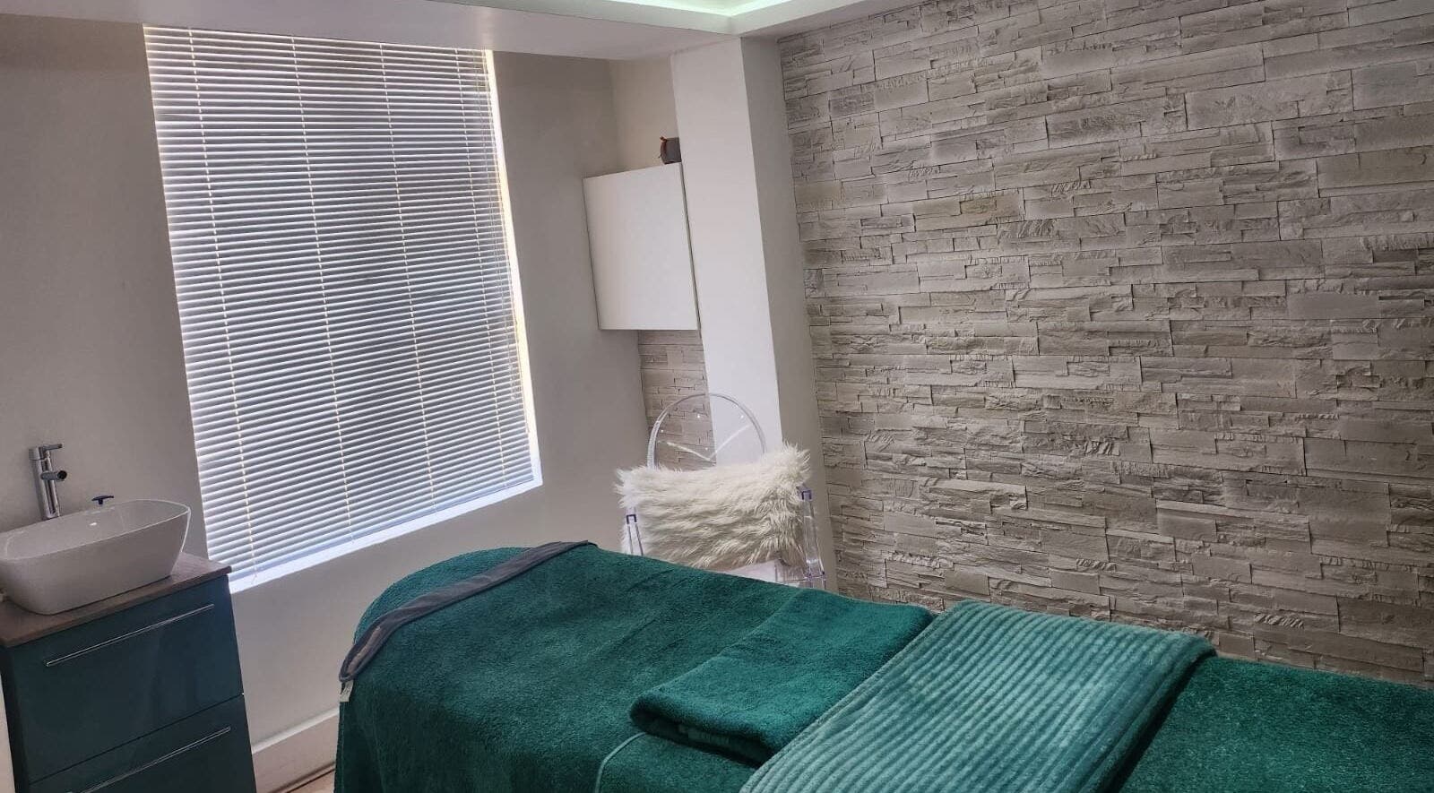 Tranquil treatment room at The Skin Revision Co, Centurion, Gauteng, ZA with a plush spa bed and textured walls.