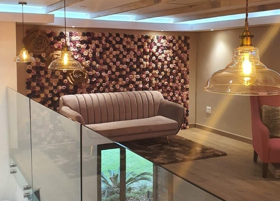 Cozy lounge area at The Skin Revision Co in Centurion, Gauteng, ZA, featuring plush seating and floral decor.