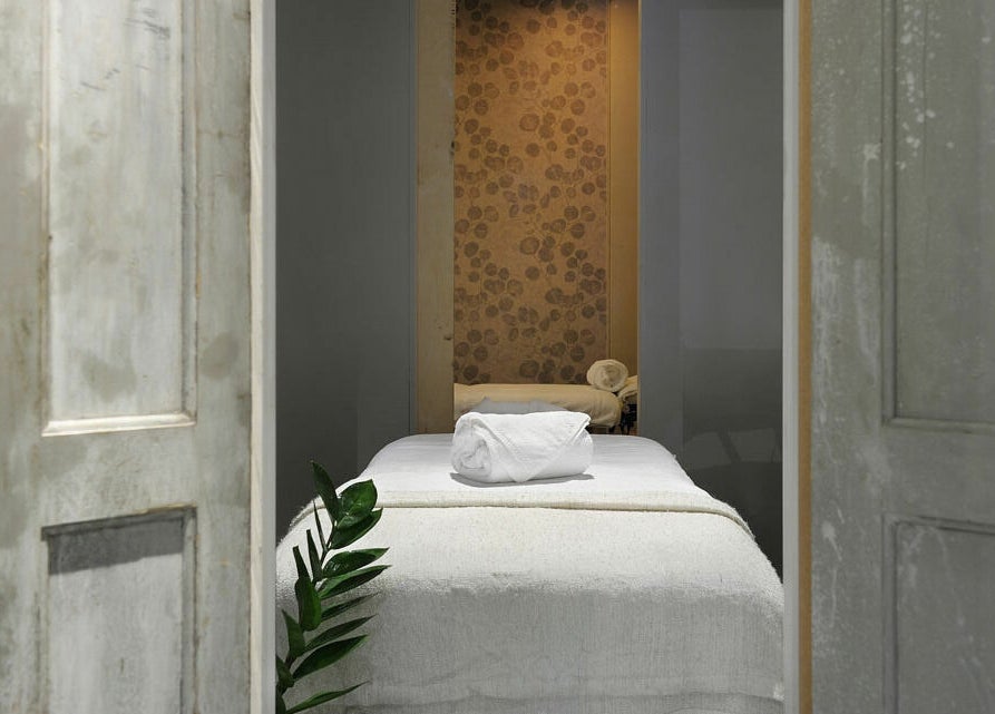 Knusse behandelkamer bij Spa Manda, Haarlem, Noord-Holland, NL, met rustieke deuren en zachte handdoeken.