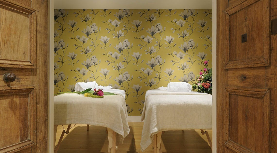 Dubbele behandeltafels bij Spa Manda in Haarlem, Noord-Holland, NL met bloemenmuur als achtergrond.