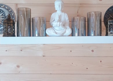 Decorative shelf with Buddha statue and lanterns at Kent Professional Makeup and Therapies, Ryarsh, England, GB.