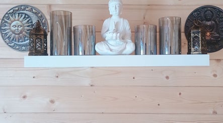 Decorative shelf with Buddha statue and lanterns at Kent Professional Makeup and Therapies, Ryarsh, England, GB.
