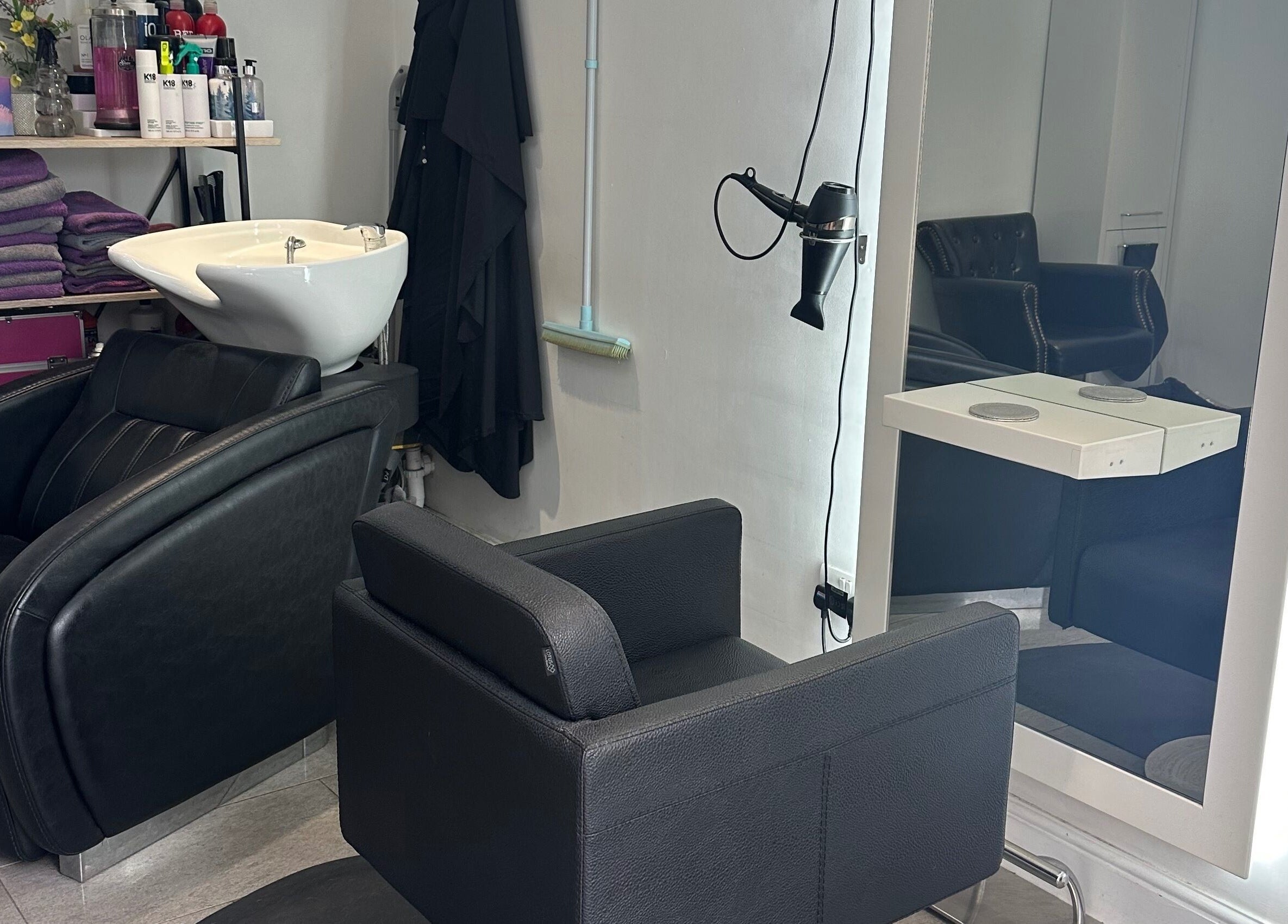 Modern salon setup at Shellee at Salon 31, Hempstead, England, GB with sleek black chairs and wash basin.