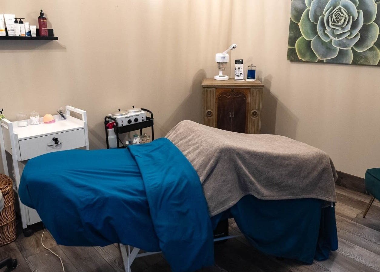 Cozy massage room at In the Spalight, Dickson, Tennessee, US, with a bed and beauty products.